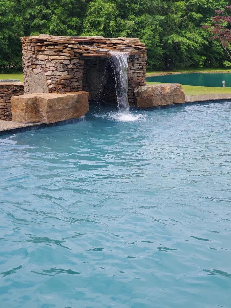 Custom in-ground pool with waterfall feature built by Robinson Inc